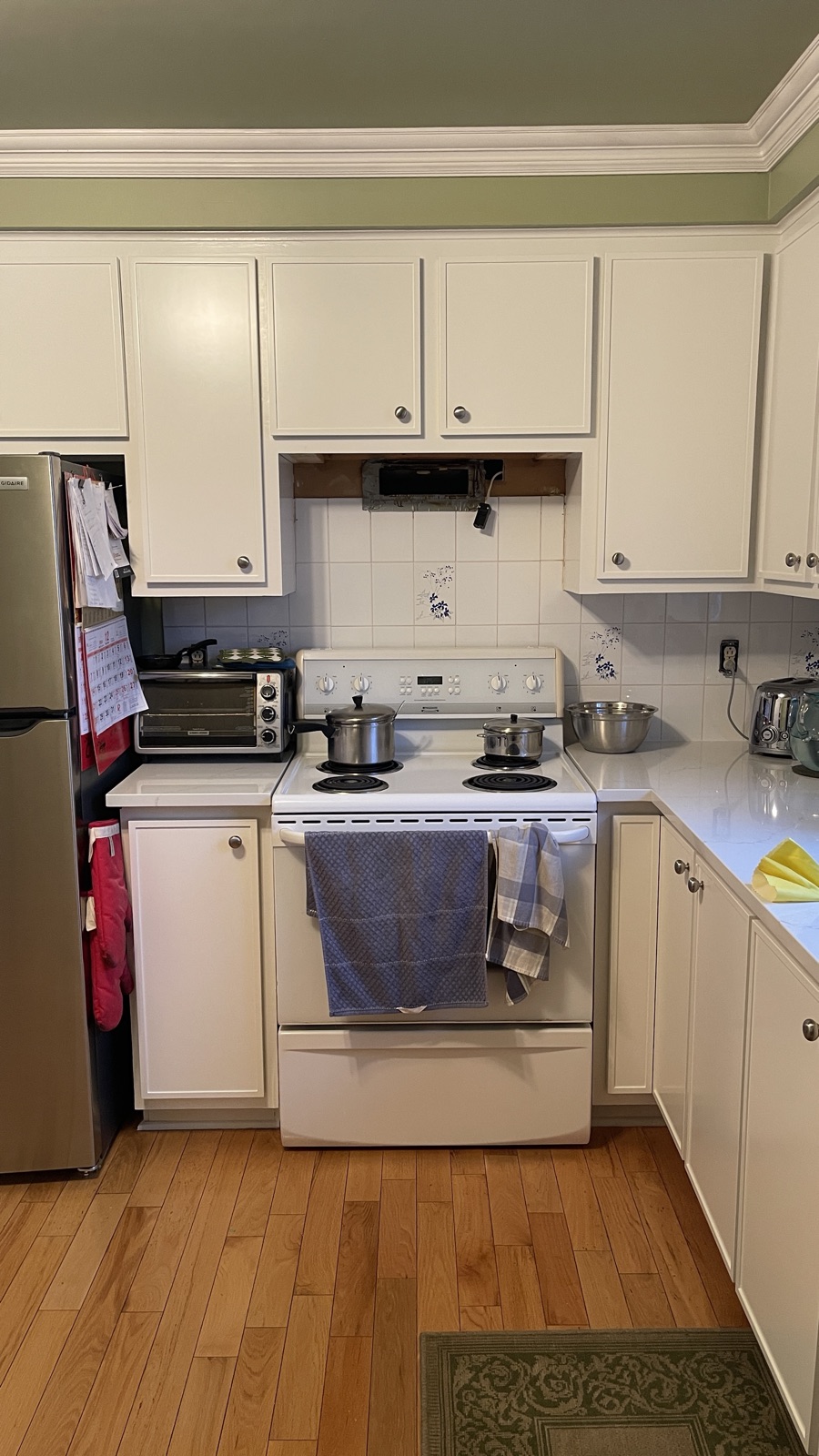 Pendant le chantier — portes refaites et comptoir de quartz posés ; emplacement de la hotte ouvert avant la pose de la neuve