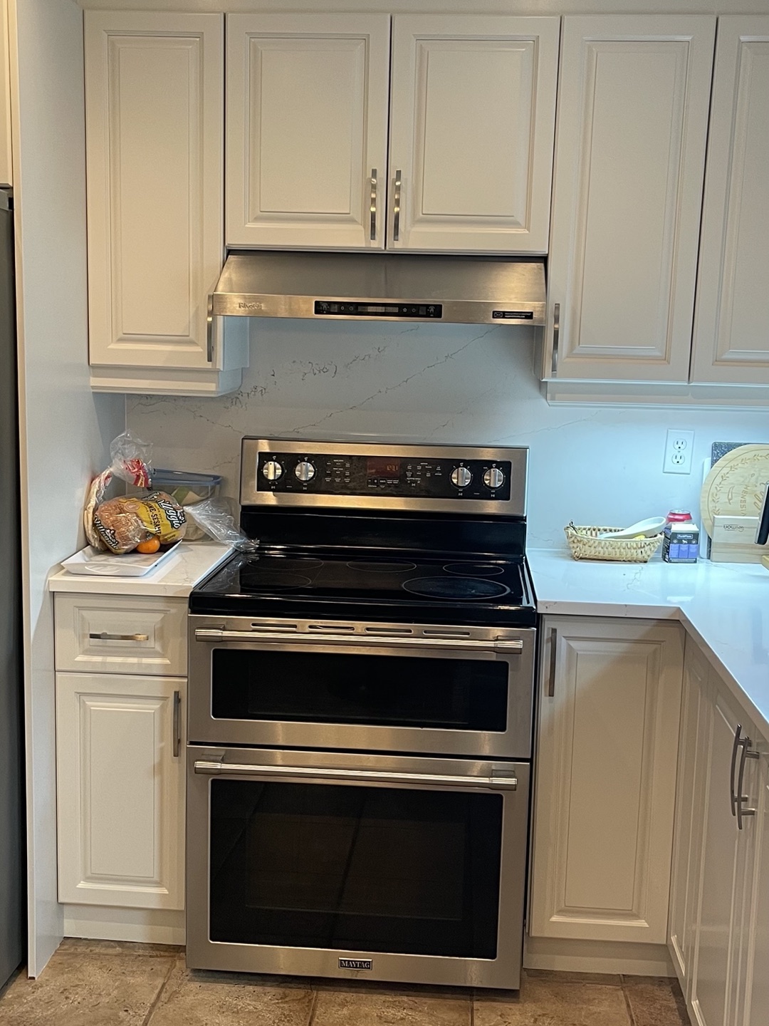 Mur de la cuisinière — dosseret de quartz, hotte inox